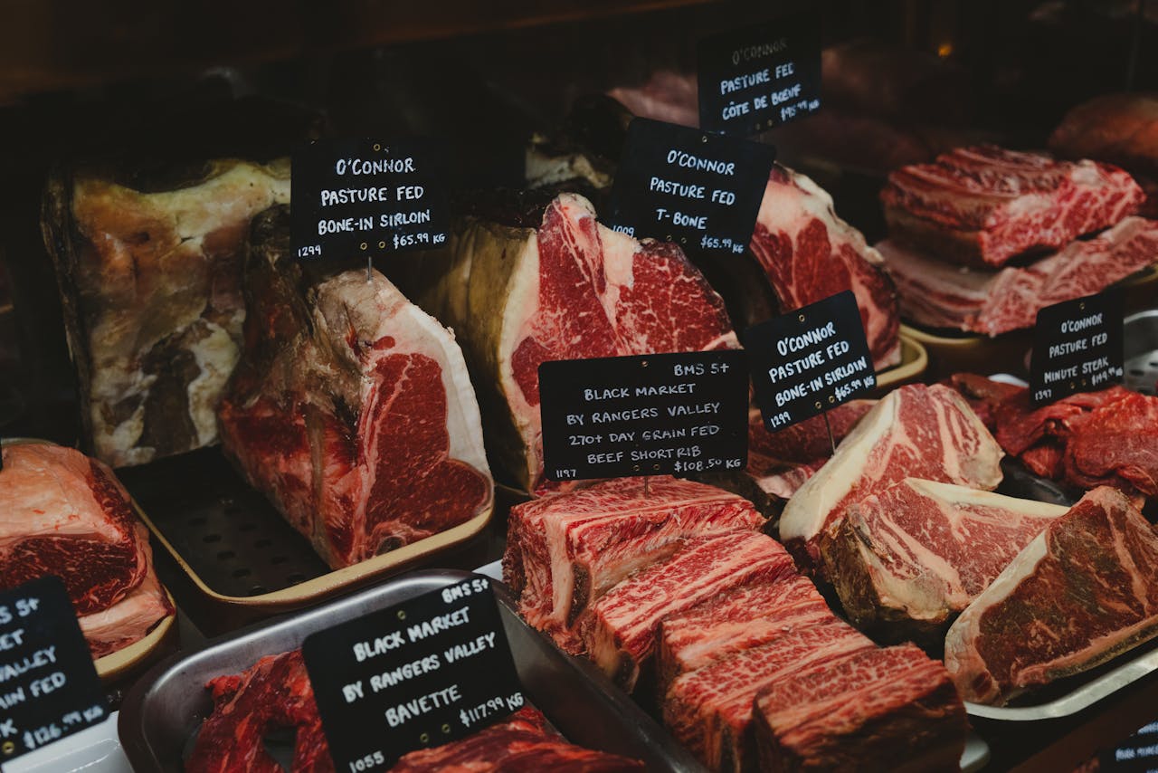 gallery-03 Assorted premium beef cuts with labels showcased in a gourmet market setting.