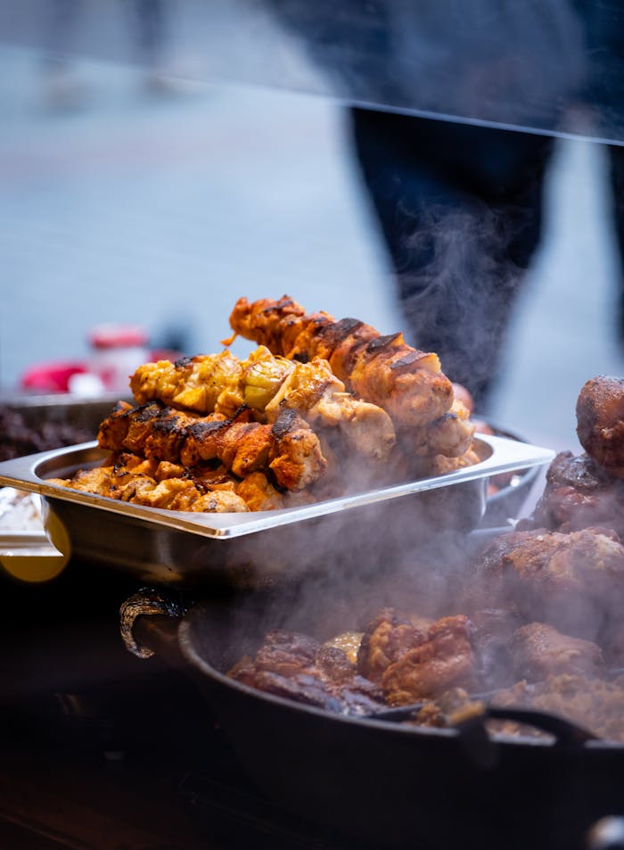 Delicious grilled meat skewers steaming at an outdoor market, evoking a vibrant culinary scene.