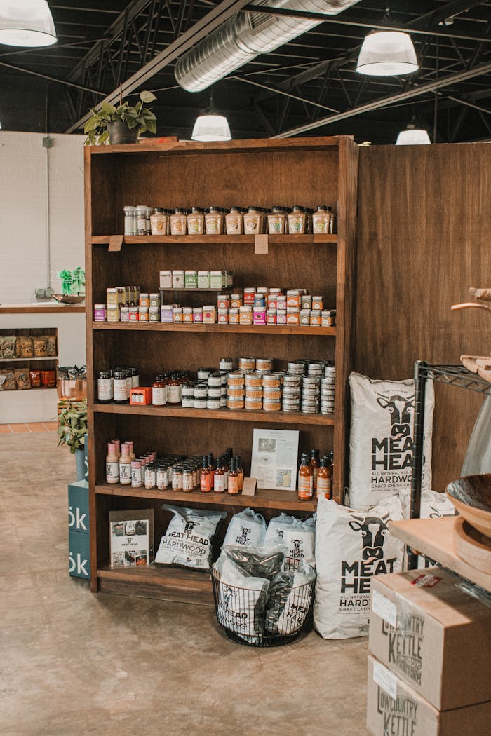 Wooden shelf showcasing a variety of local meat products and spices inside a butcher shop.