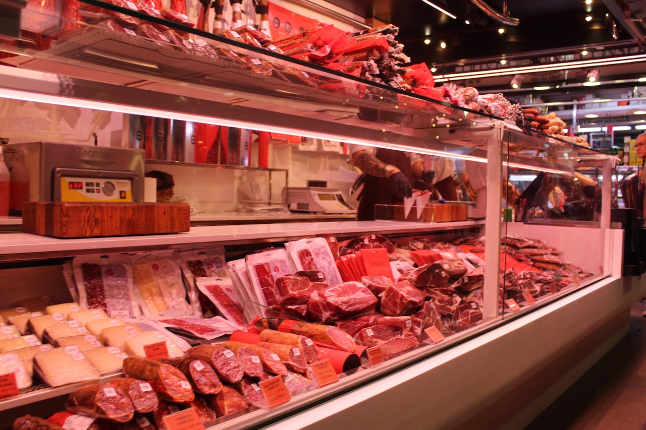 gallery-04 Fresh meat selection in a Barcelona market deli, vibrant display and diverse cuts.
